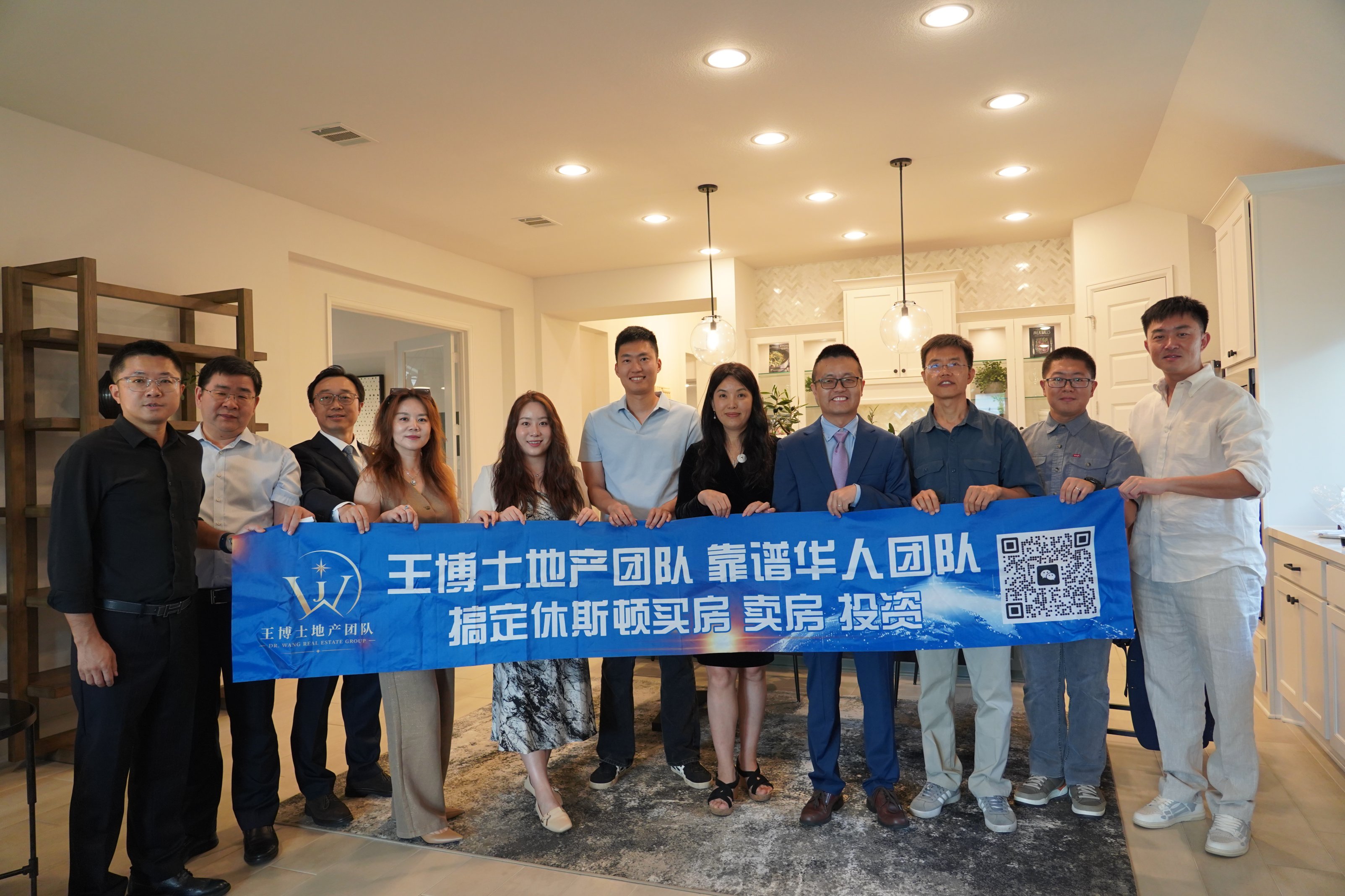 团队成员手持王博士地产团队横幅合影