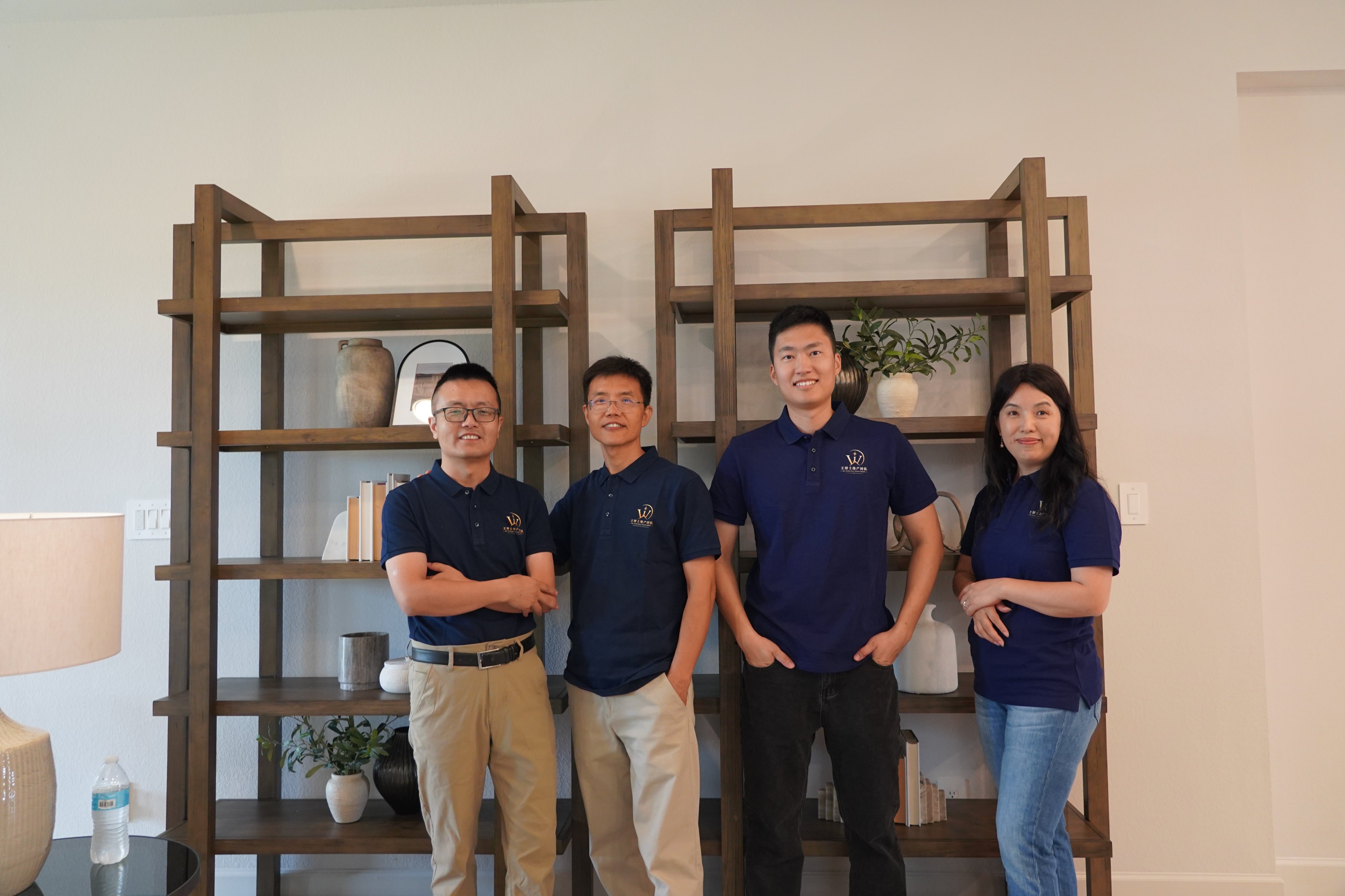 四位团队成员身穿藏青色团队 Polo 衫合影