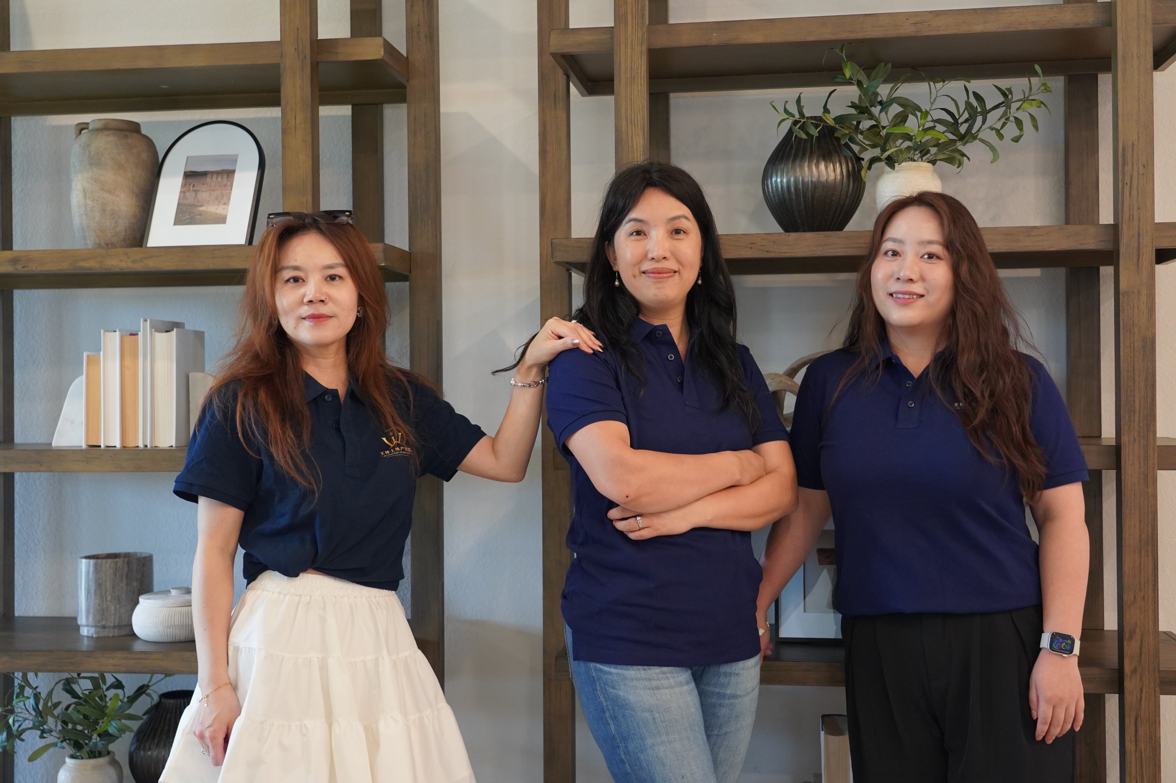 三位女团队成员身穿藏青色团队 Polo 衫合影